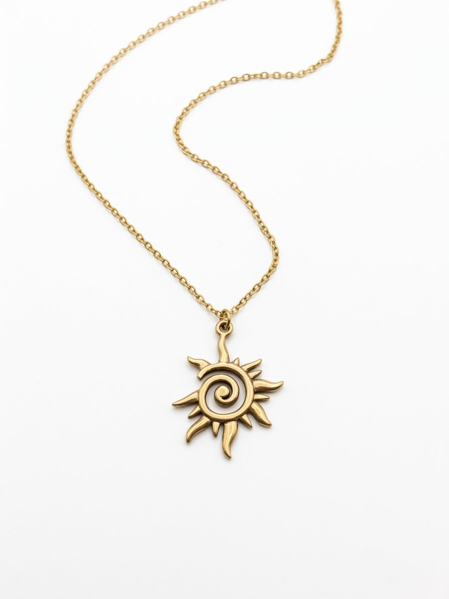 Close-up of the gold celestial sun pendant with spiral detail.