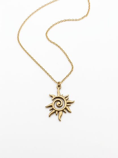 Close-up of the gold celestial sun pendant with spiral detail.