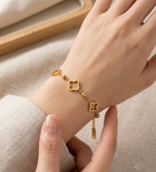 Woman wearing the Lumina Manor Celeste Clover gold stainless steel bracelet.
