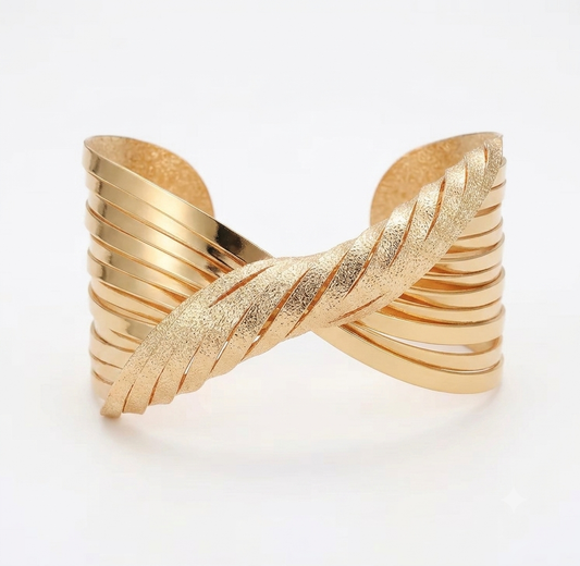 A gold-toned twisted cuff bracelet with a textured, ribbed design by Lumina Manor